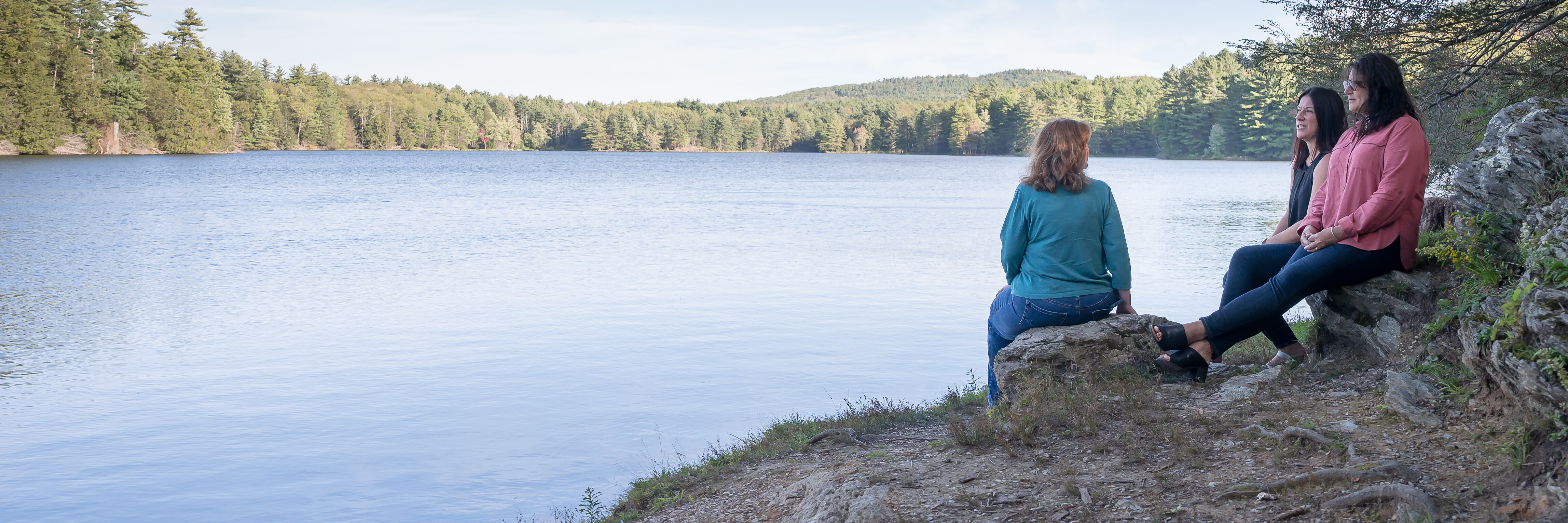 Rose law attorneys sitting outdoors by a lake